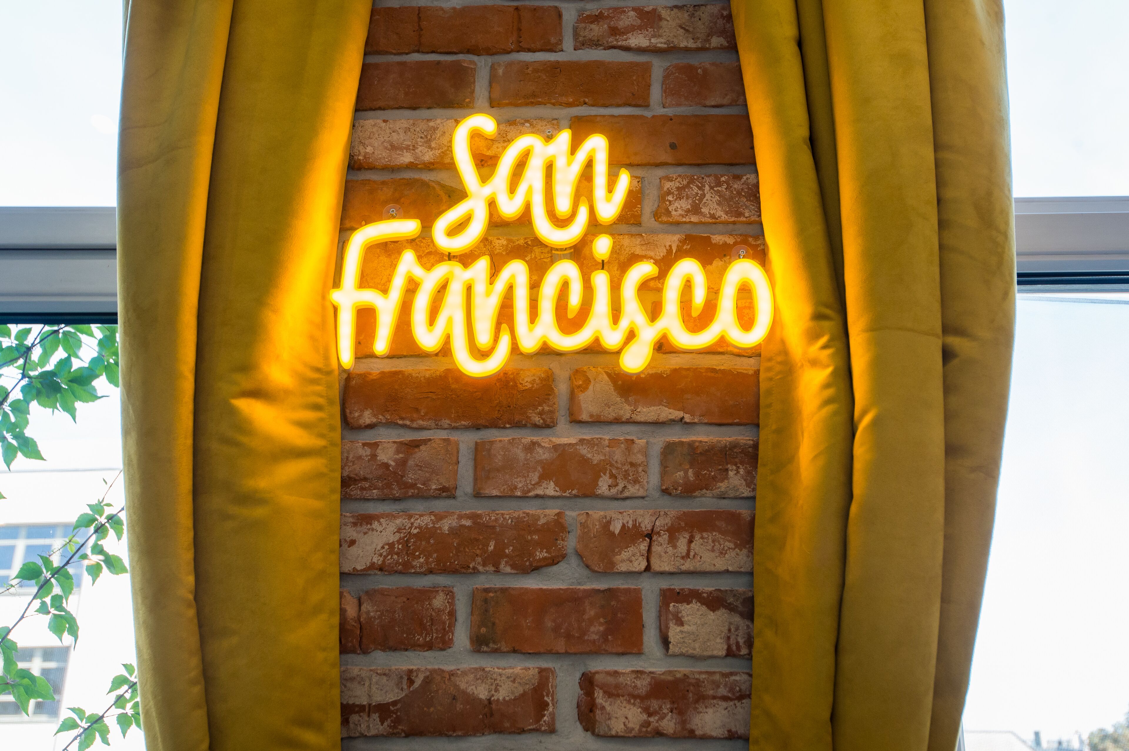 A neon sign reading "San Francisco" on a brick wall.