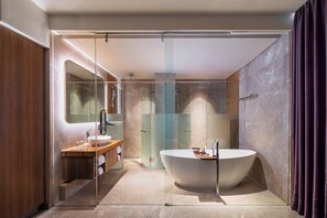 Junior Suite King Bed, Non Smoking | Baño | Regadera, amenidades de baño gratuitas, pantuflas, toallas 