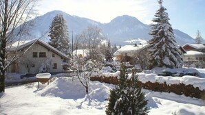 A snowy residential area with houses and mountains in the background. - Apartment Almrausch 75sqm, balcony, kitchen, 1 bedroom, 1 living room, WLAN (Ruhpolding)