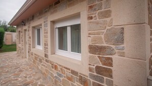 A stone building with two windows and a stone pathway. - Casa de Piedra Playa de Estorde con vistas al mar (Cee)