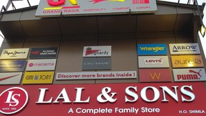 Una tienda llamada LAL & SONS, un comercio familiar completo, con maniquíes mostrando ropa en la entrada.