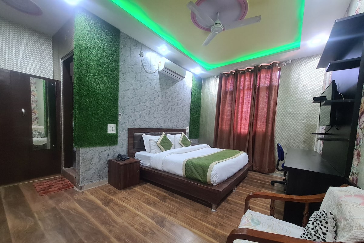 A bedroom with a bed, bedside table, and a desk with a chair.