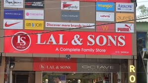 Fachada de hotel con varios anuncios de marca, incluyendo Anurag's, Grand Raga y Lal & Sons.
