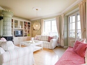 Ein Wohnzimmer mit einer Couch, einem Couchtisch, einem Fernseher und einem Bücherregal.