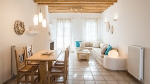 Una sala acogedora con una mesa de comedor de madera, sillas, un sofá y una chimenea.