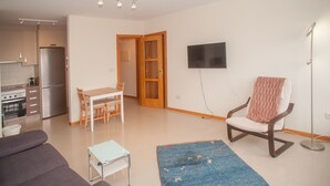 A modern apartment with a kitchen, dining area, and living room.