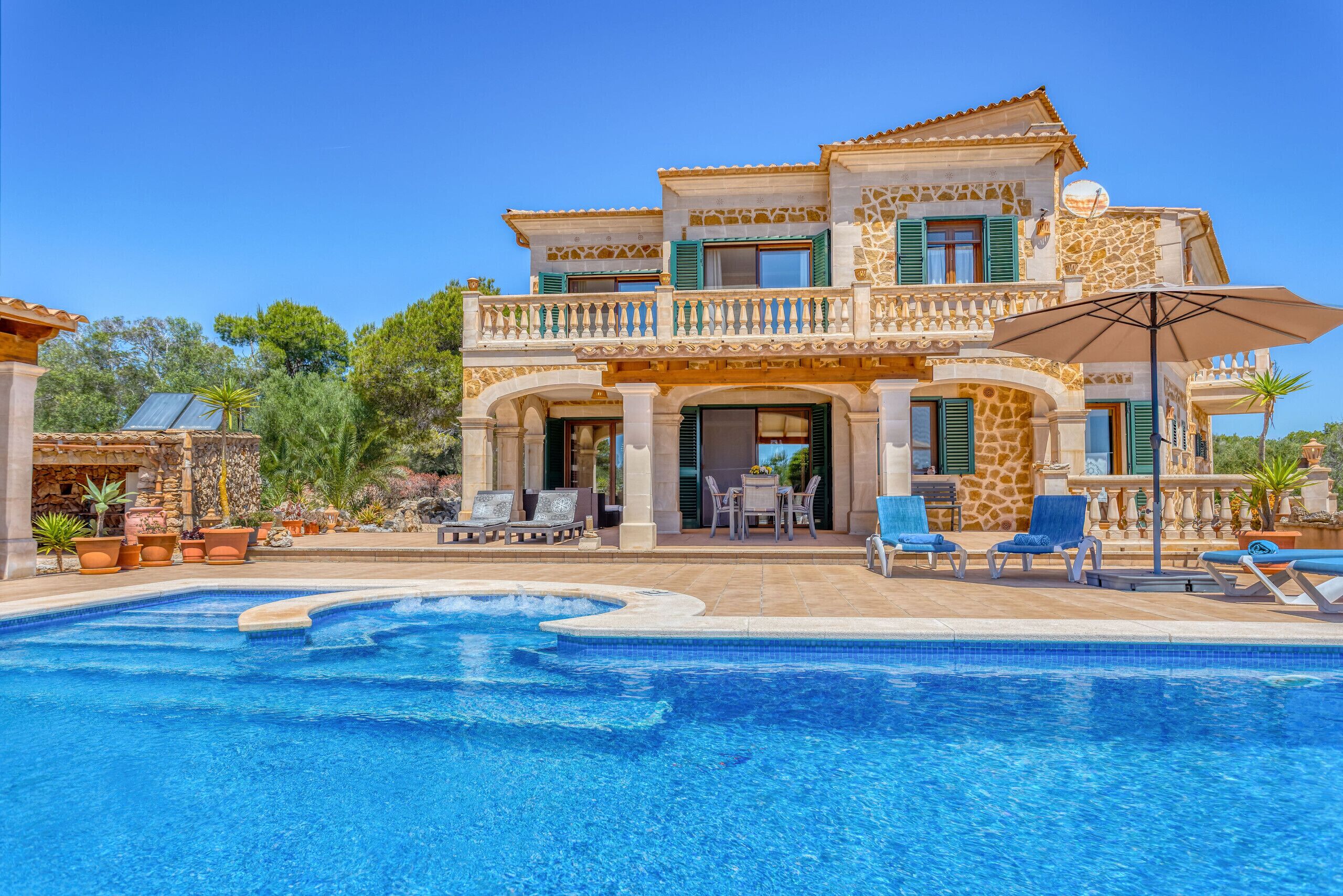 Une maison à deux étages avec une piscine, un espace salon extérieur et un patio.