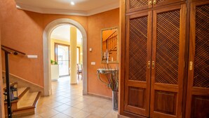 Un couloir avec une porte en bois, une porte en verre et un escalier.