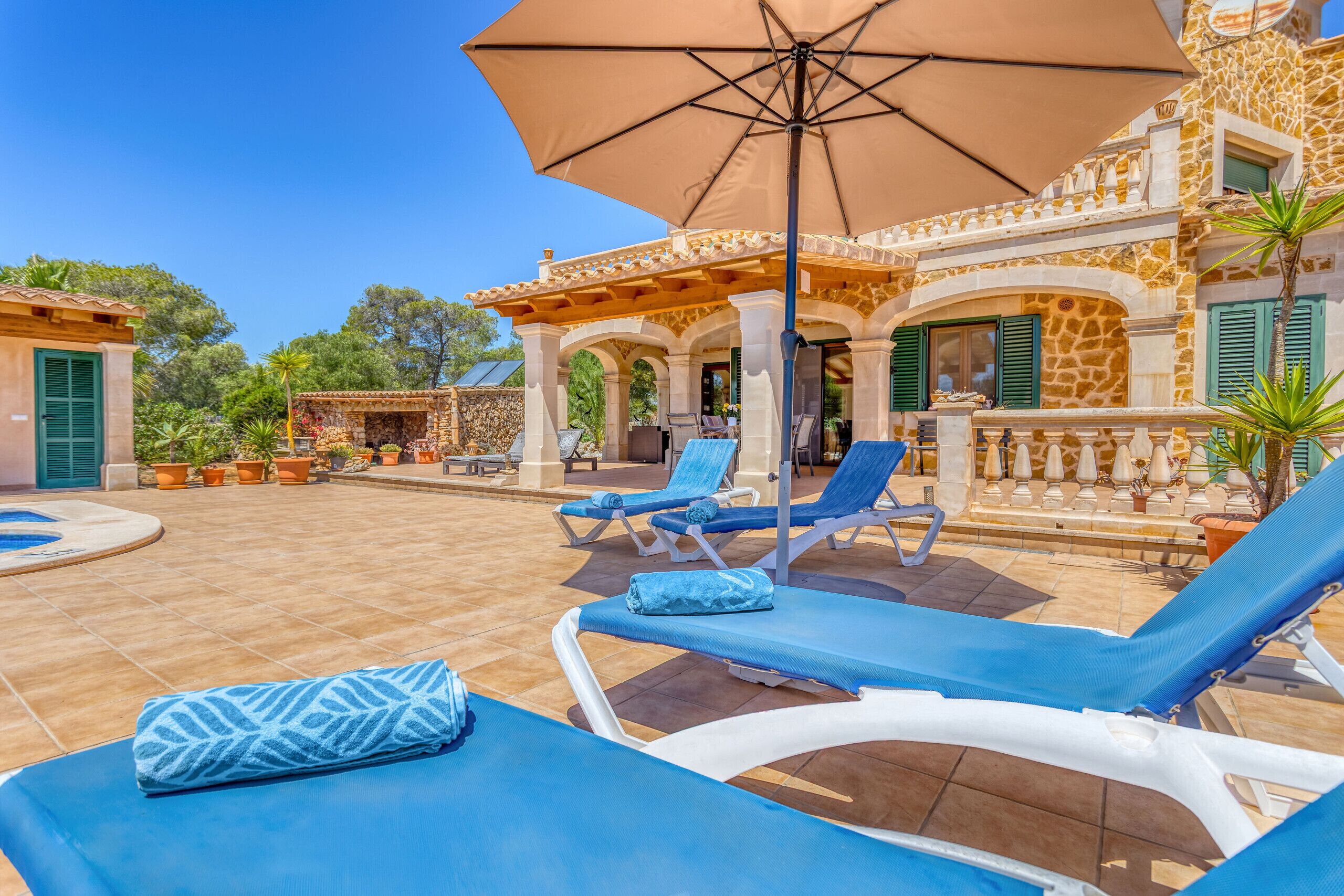 A poolside area with lounge chairs and an umbrella.