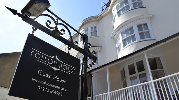 Señal de Colson House, una casa de huéspedes, con información de contacto y URL del sitio web.