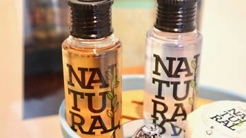 Dos botellas con la etiqueta 'NATURAL' y un diseño de planta, junto con una botella pequeña con etiqueta similar.