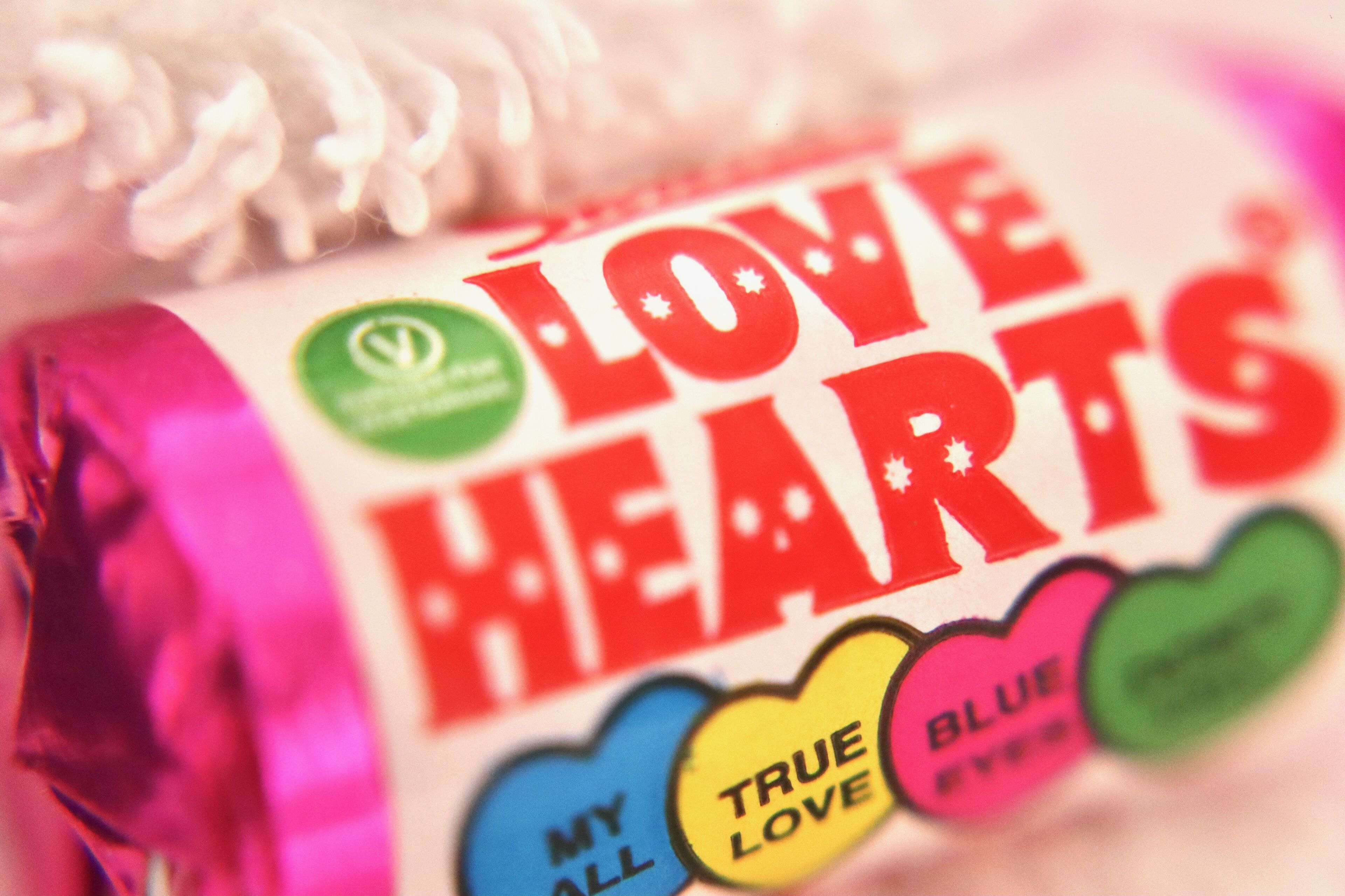 Eine Schokoladenriegel mit der Aufschrift "LOVE HEARTS" und farbenfrohen herzförmigen Etiketten.