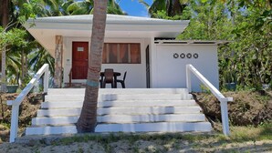 A small building with a white exterior, a red door, and a staircase leading up to a porch area. -  Chilly Beach Resort Palawan (Aborlan)