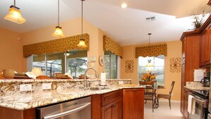 A modern kitchen with a central island, stainless steel appliances, and pendant lighting.