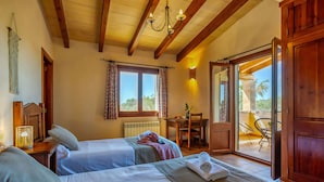 Ein Zimmer mit zwei Betten, einem Essbereich und einem Balkon mit Aussicht.