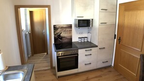 Une cuisine compacte dotée d’un four encastré, d’un four à micro-ondes et d’un petit plan de travail.