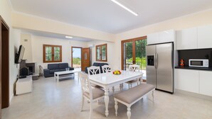 Una cocina moderna con refrigerador, microondas y comedor con mesa y sillas.