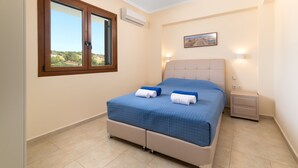 Un dormitorio con cama, mesita de noche, ventana y aire acondicionado de pared.