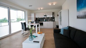Un espace de vie moderne comprenant une cuisine, un coin repas et un balcon avec vue.