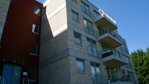 Un immeuble à plusieurs étages, doté d’une façade rouge et d’une partie supérieure grise.