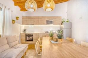 A modern kitchen with wooden cabinets, a built-in microwave, and a refrigerator.