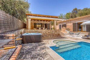 A backyard with a hot tub, a barbecue grill, and a swimming pool.