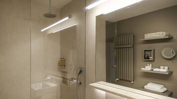 Une salle de bain moderne avec une douche à parois de verre, un lavabo, un miroir et un porte-serviettes.