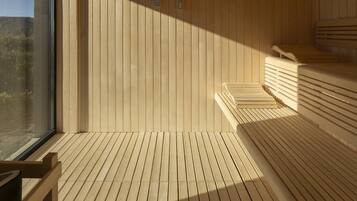 Uma sauna de madeira com bancos e uma janela grande.