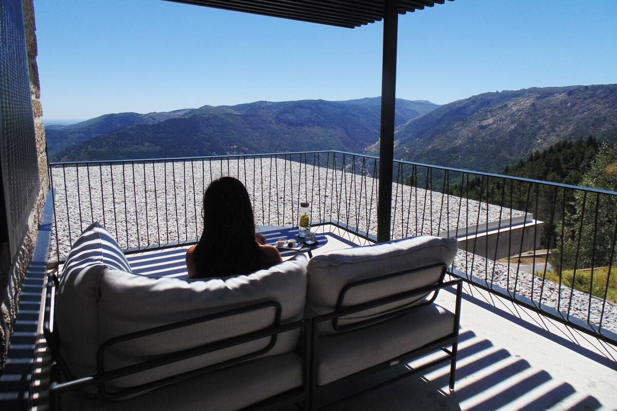 A balcony with a view of a mountainous landscape.