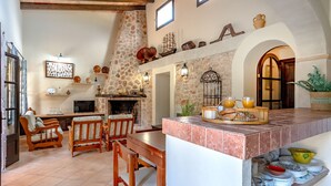 Un salón acogedor con chimenea, muebles de madera y una pared de piedra.