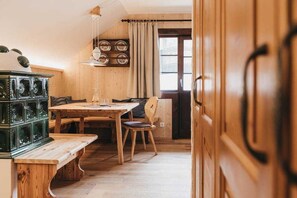 Un interior de madera con una mesa de comedor, sillas, un banco y un mueble verde.
