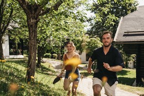 Dos personas trotando por un sendero pavimentado en una zona residencial con árboles y una casa al fondo.