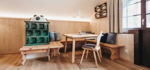 Un interior de madera con una mesa de comedor, bancos y un armario verde.