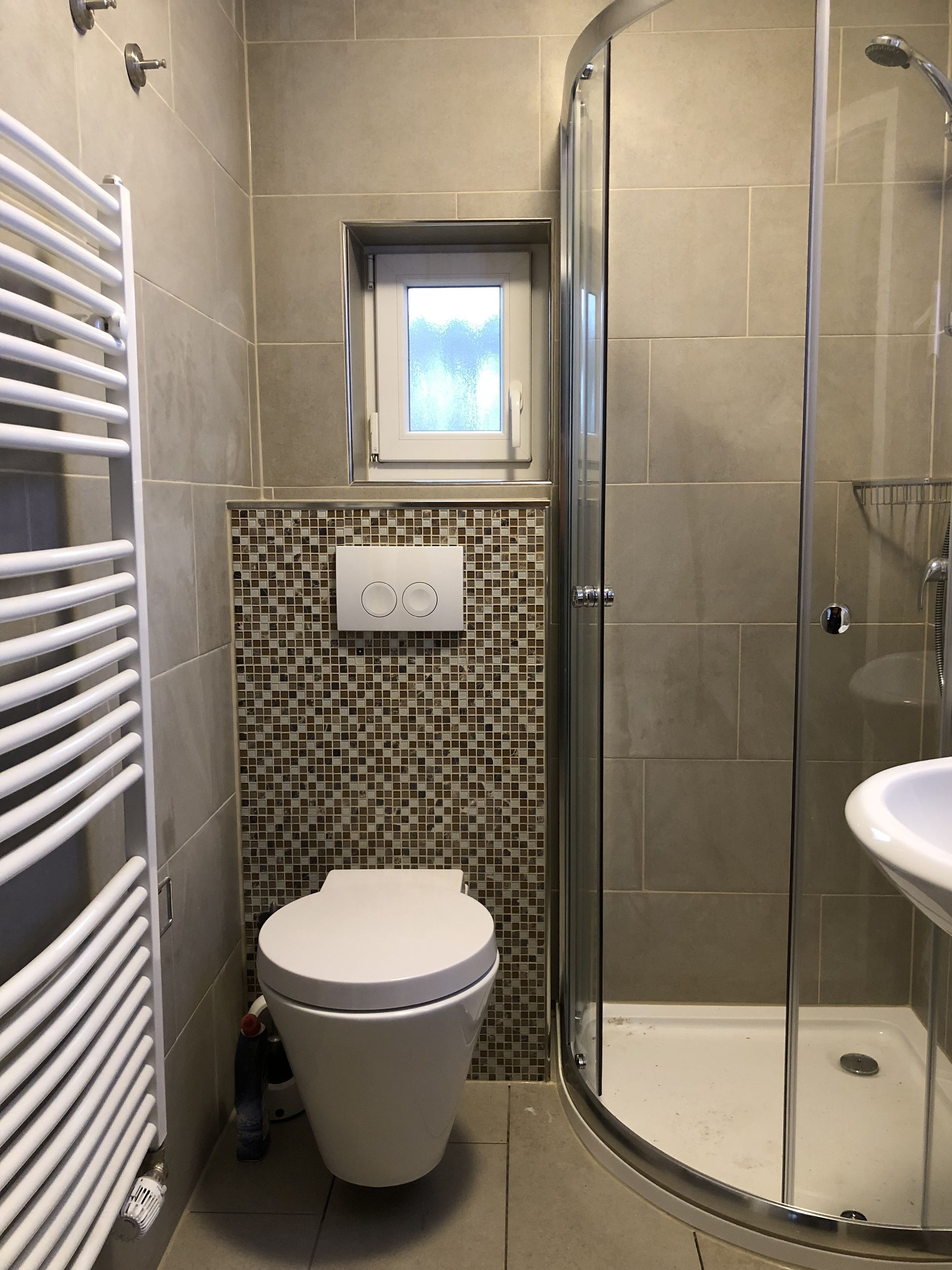 A bathroom with a toilet, a shower, and a sink.