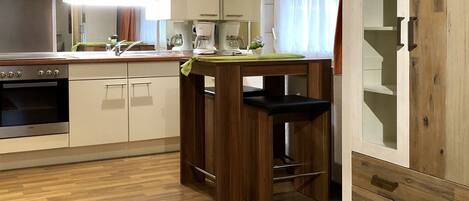 A modern kitchen with wooden cabinets, a built-in oven, and a coffee maker.