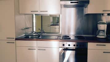 A modern kitchen with stainless steel appliances, including a stove, oven, and coffee maker.
