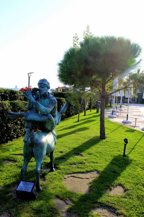 A statue of a man playing a flute in a park. - Helena Sands (Nessebar)