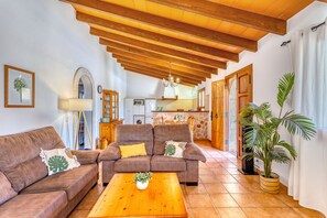 A cozy living room with a sofa, a coffee table, and a dining area.