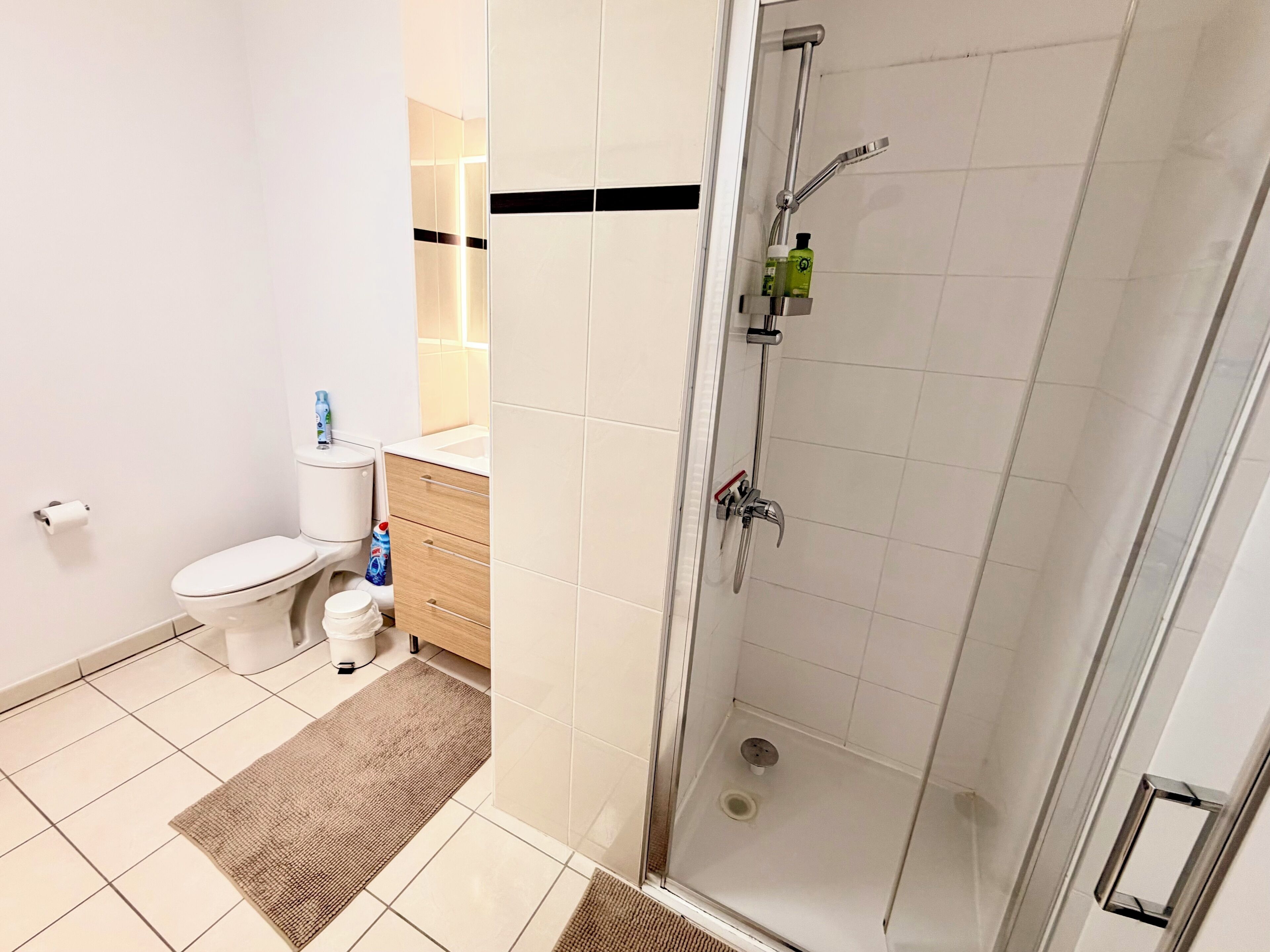 A modern bathroom with a toilet, sink, and shower.