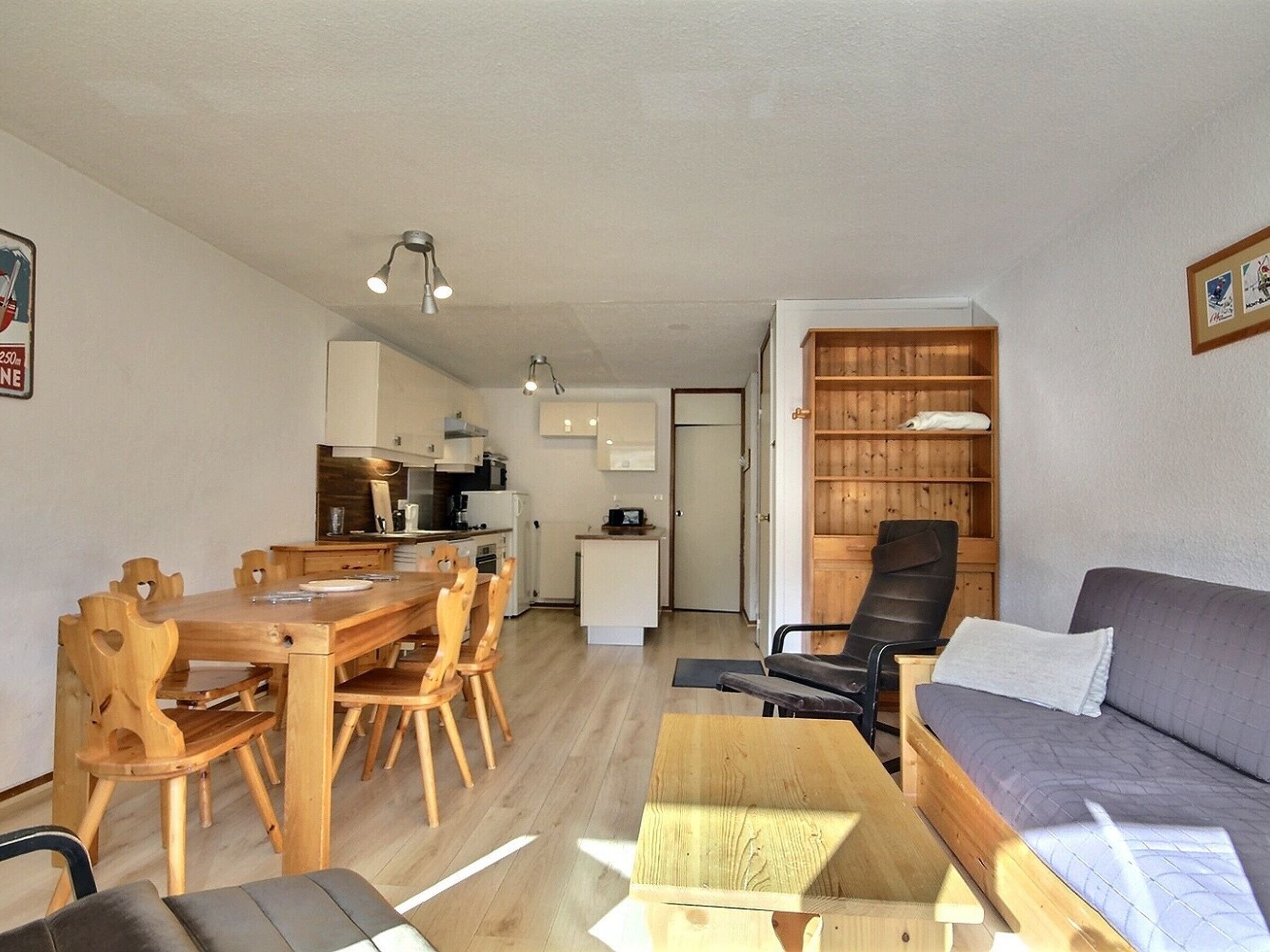 Un espacio habitable compacto con comedor, kitchenette y sofá.