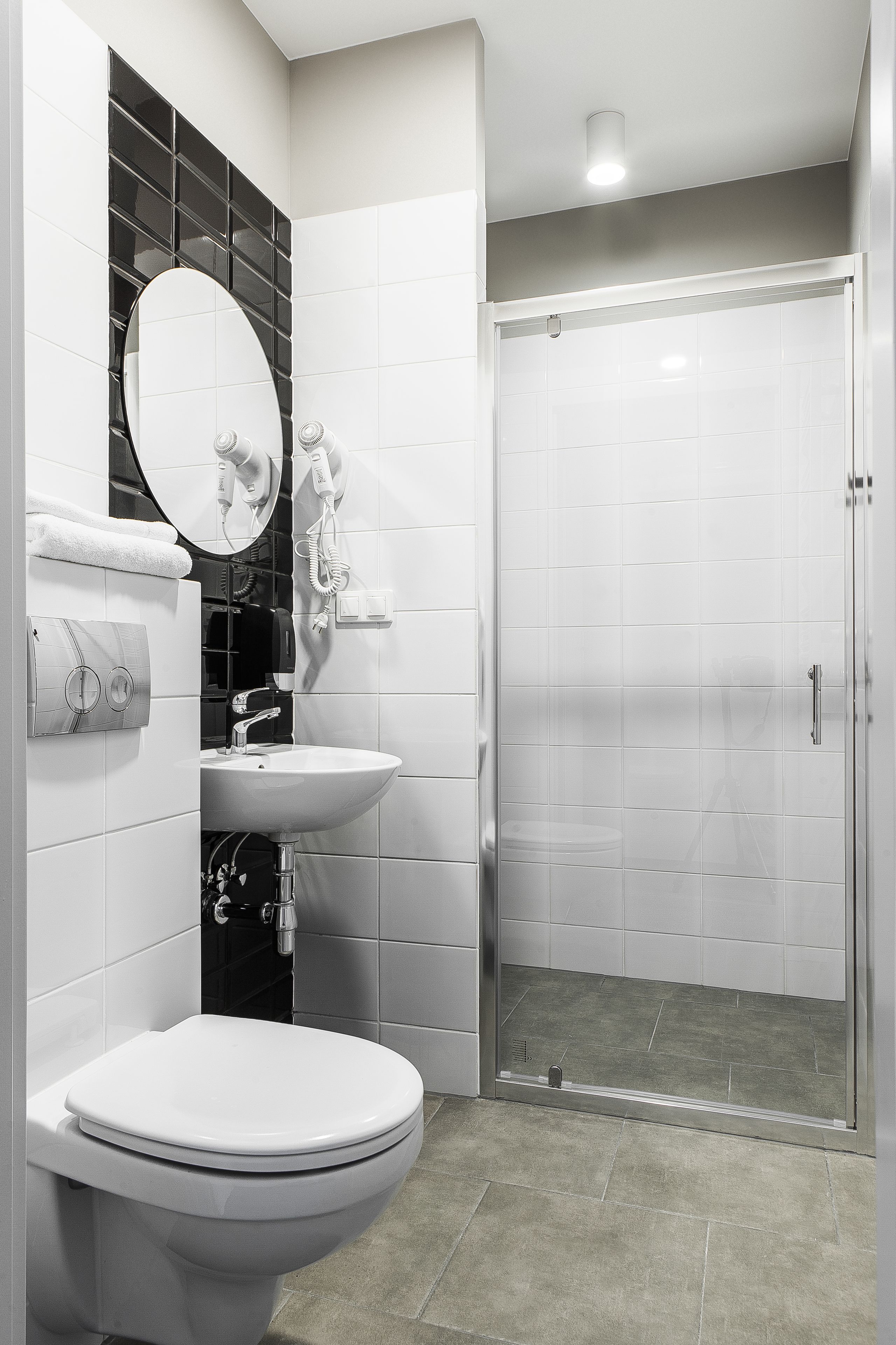 A modern bathroom with a toilet, sink, and shower.