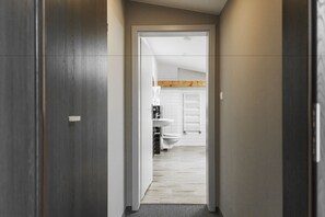 A hallway leading to a bathroom with a wooden ceiling and white tiles. - Gdynia Centrum (Gdynia)