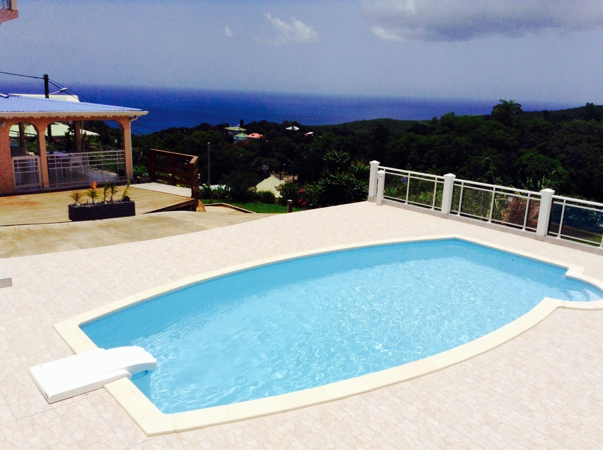 Une piscine avec vue sur l’océan et les collines.