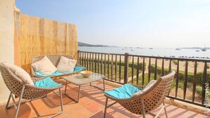 A balcony with wicker furniture and a view of the sea. - Large 3 Bedrooms flat with superb sea view (PORT GRIMAUD)
