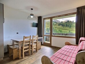 Enjoy a mountain view from the comfort of this cozy room, featuring a desk, chair, and flat-screen TV.