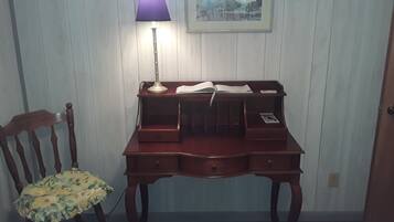 Ein Holztisch mit Schubladen, einer Lampe und Papier.