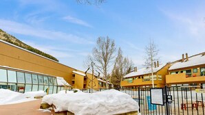 A building with large windows, a snow-covered ground, and a clear sky.