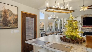 A kitchen with a granite countertop, wooden bench seating, a Christmas tree, and a fireplace. - Adventures-Historic Deadwood- Trails- ATV- Skiing-Trolly-Private Acreage (Deadwood)