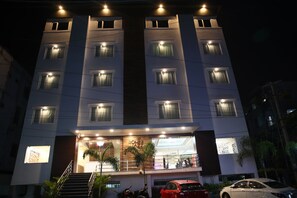 A multi-story hotel with illuminated windows and a visible entrance. - Rohhotel (Visakhapatnam)