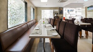 Un restaurant doté d’un long comptoir, de banquettes et d’un plafond haut.